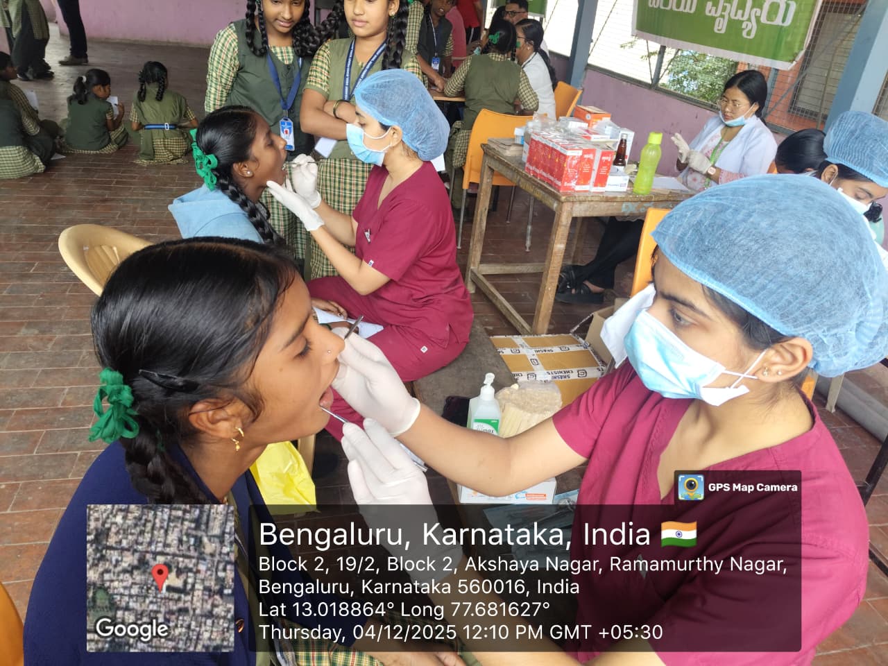 Female dentist examining a student's teeth during the camp